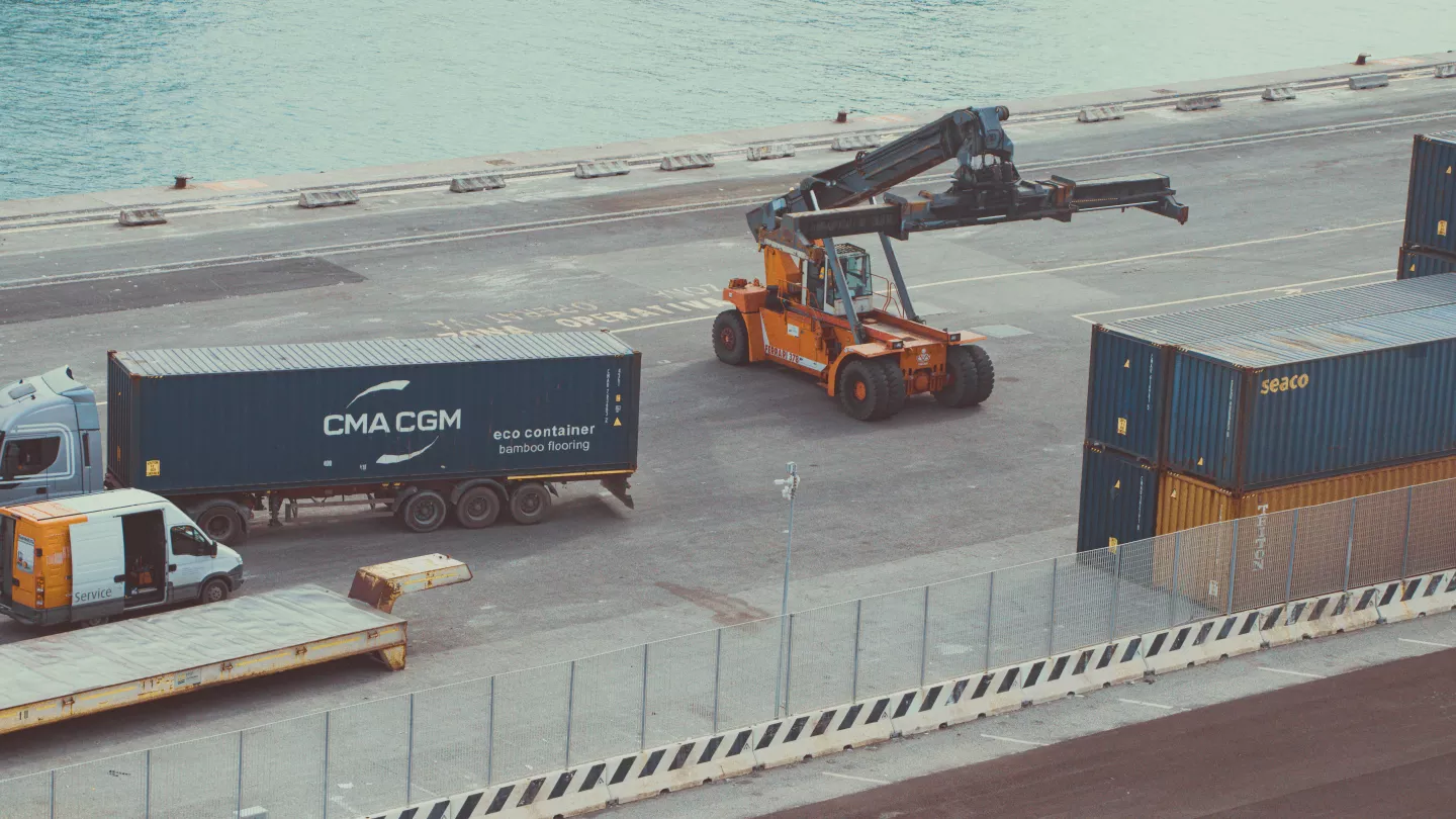 https://www.pexels.com/fr-fr/photo/operations-de-terminal-a-conteneurs-avec-chariots-elevateurs-et-camions-38754476/
